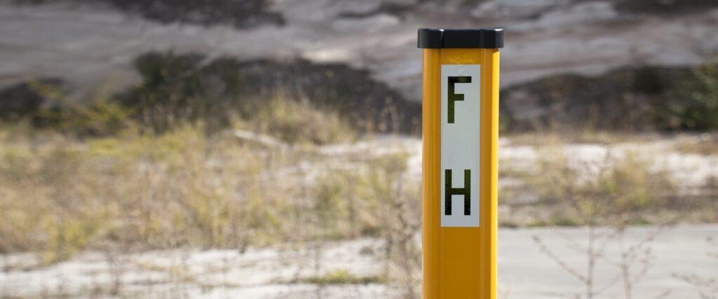 Yellow marker post with rolled edges