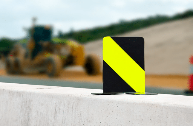 small black and yellow delineator on a safety barrier