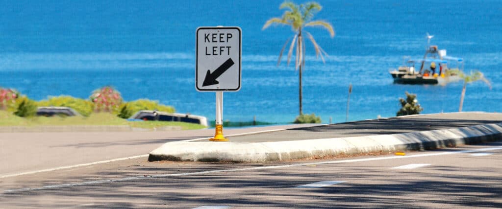Keep left sign next to the water on an impact support